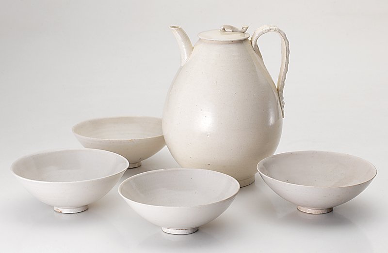 北宋〈定窯梨型蓋壺連茶盞〉一套，蓋壺高19厘米、盞徑12厘米。