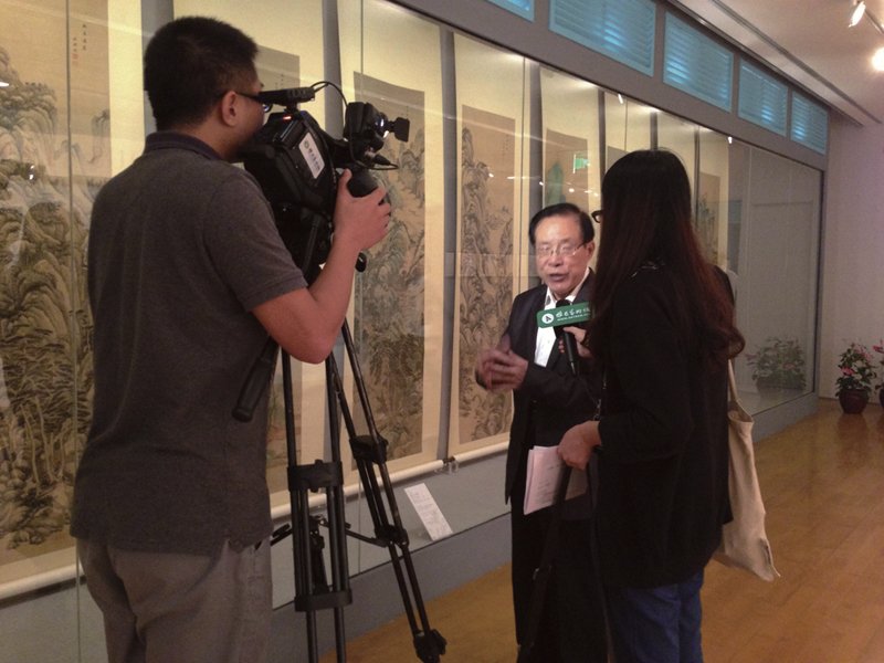 北京故宮研究員單國強接受媒體訪問，後方作品為王鑑所畫的〈仿古山水圖〉12屏，上海博物館藏。