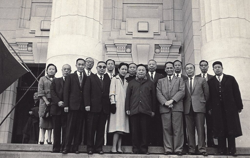 1970年代，日本訪問團來台，高逸鴻（右立者）即席揮毫，其右側為前教育部長蔣彥士，後為歷史博物館館長何浩天。