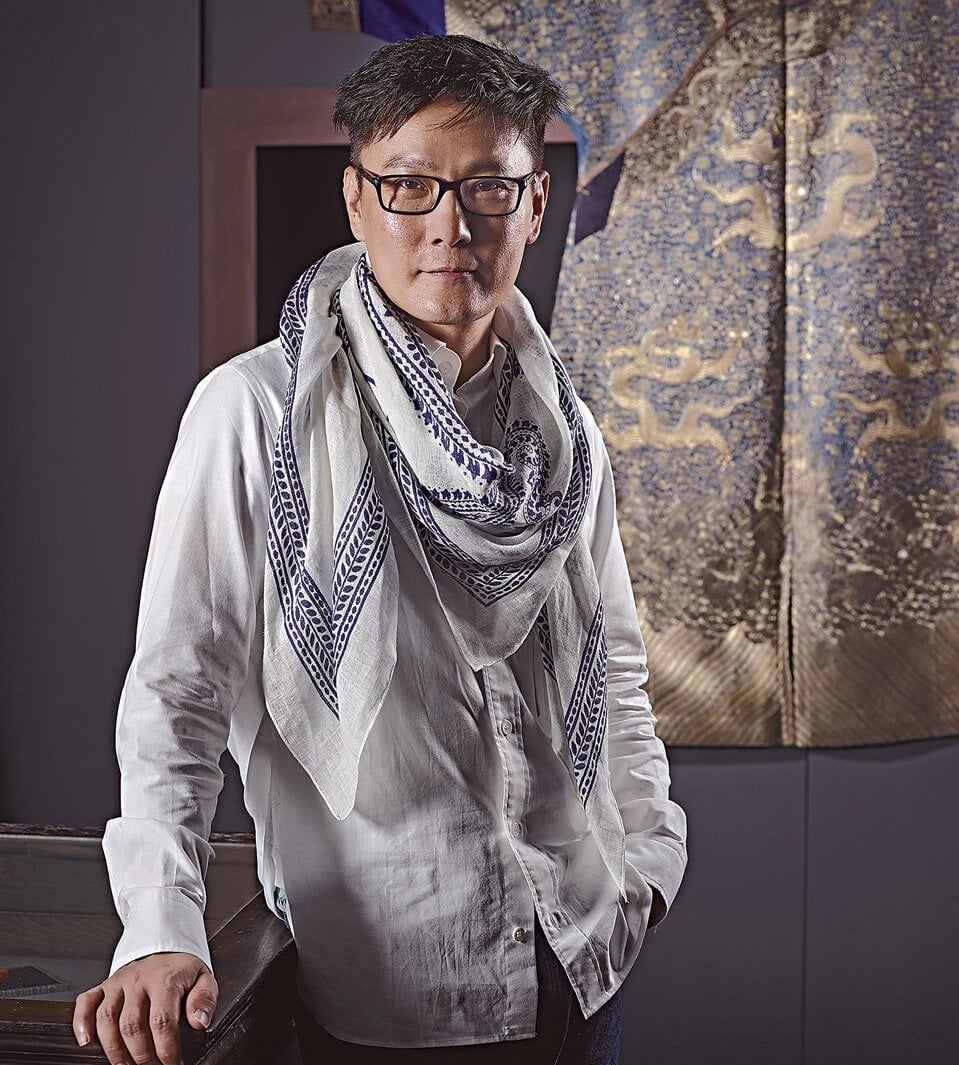 張信哲。其後為清乾隆〈藍色綢平金銀繡雲龍紋龍袍〉,176×137公分。