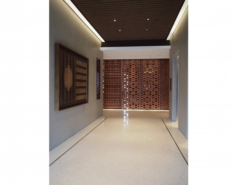 二樓梯廳處,牆面上的作品為江賢二的作品《故鄉》,以燈籠表現出故鄉的意象,紅色磚牆為粘錦成帶領年輕團隊共同完成,賦予傳統工法新的生命。攝影:柯舒寧