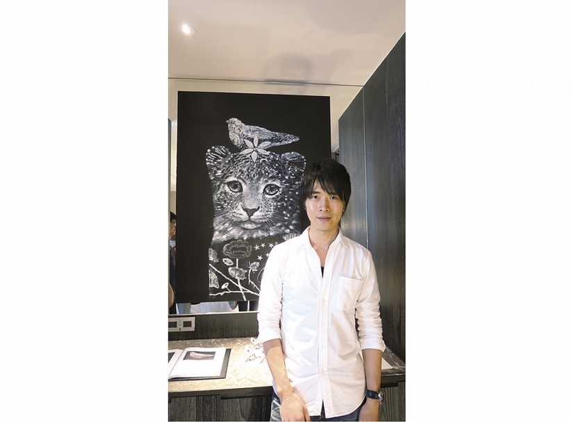 觀止堂展間的台灣藝術家蘇修賢與作品《siliver saint clothes》合影。（攝影／楊椀茹）