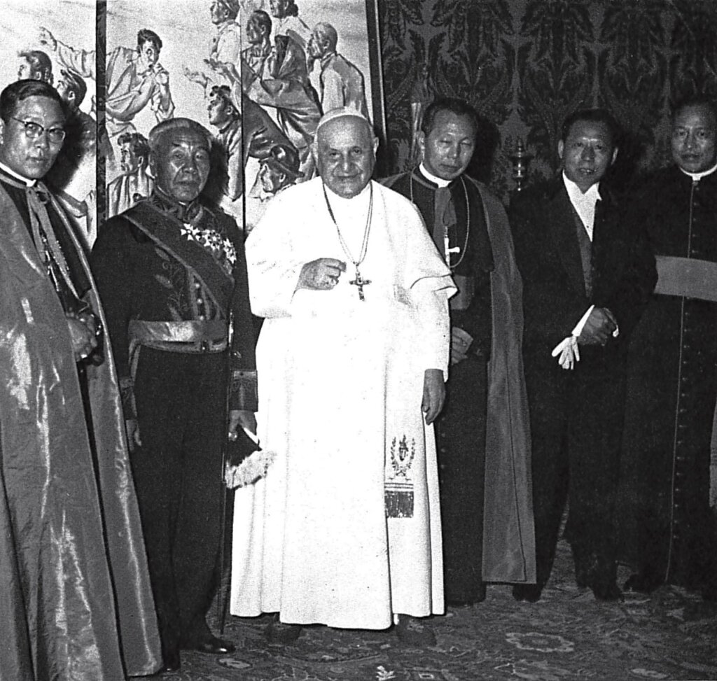 郭明橋（右二）於1961年榮獲梵蒂岡教宗23世封為爵士，頒予騎士勳章，背景為其所繪之〈大陸血淚圖〉。此照攝於1962年。