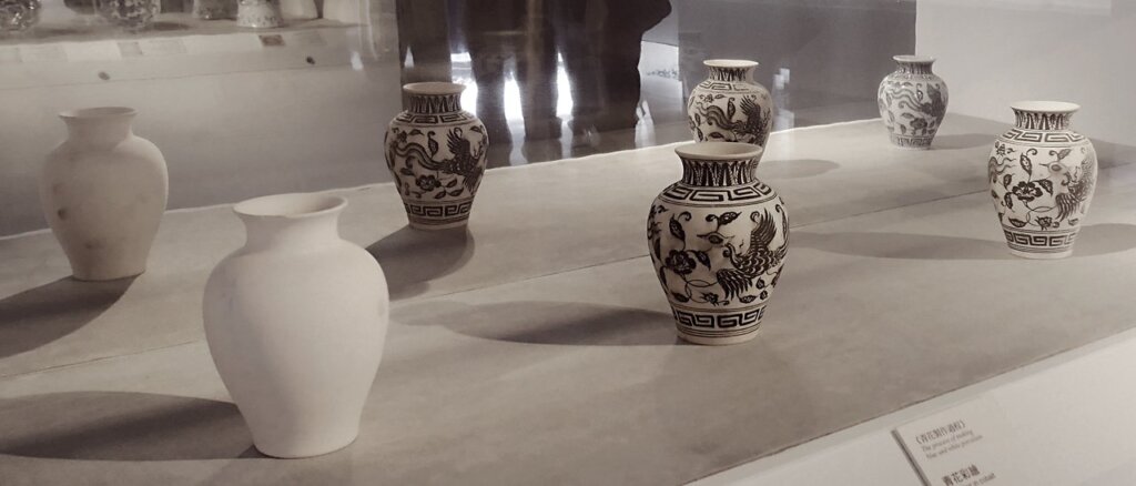 由左至右為：青花鳳紋素瓷→在坯體上以鈷彩繪→噴灑透明釉→燒製完成。攝影／王怡文。