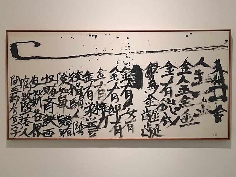 井上有一後雖受芭蕉、良寬等詩僧影響甚深,但他的多文字書寫卻也直指日本當代社會的拜金與腐敗之象。「人生一金,金金金金。金有總有。為金齷齪。金有,女有。金有,邸有。金有權力。金有榮譽。狡猾騙人,陰險如鼠。贈賄收賄,齊鐵面皮如斯,各界腐敗墮落。人間要諦,有貧一字。」圖為《人生一金》(1978,71x146cm,個人藏)。