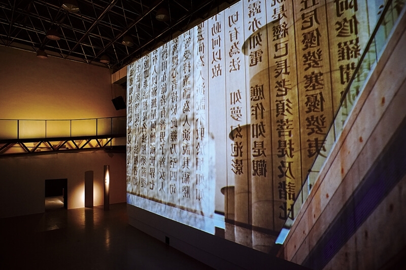 「喧囂與寂靜」展廳，是由200多根圓柱構成直徑10米的圓形空間，圓柱上滾動播放著《心經》的章節。圖／上海當代藝術館