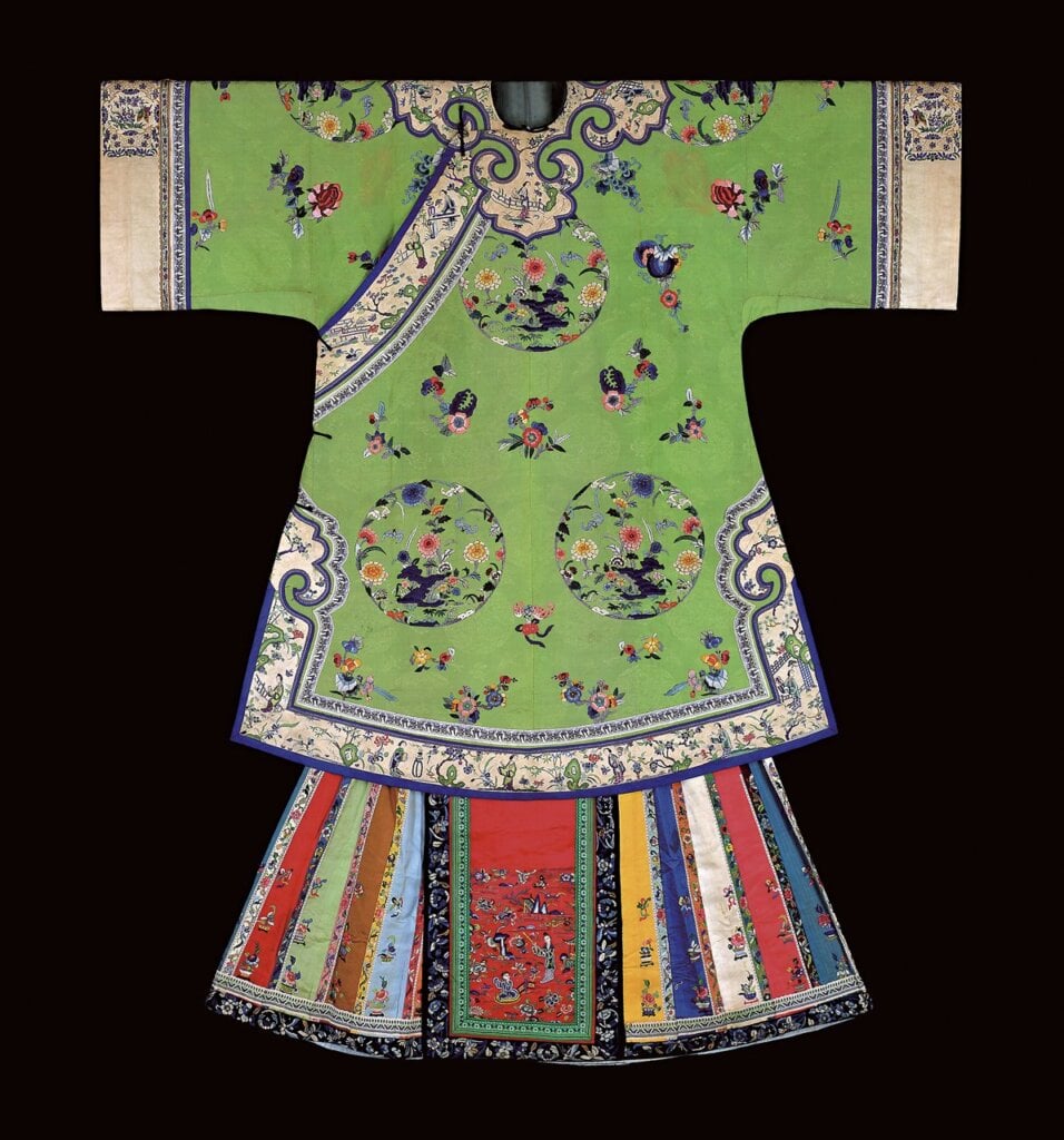 清代〈青綠暗花緞繡彩蝠團花地女袍、五彩緞繡花蝶馬面裙一套〉。