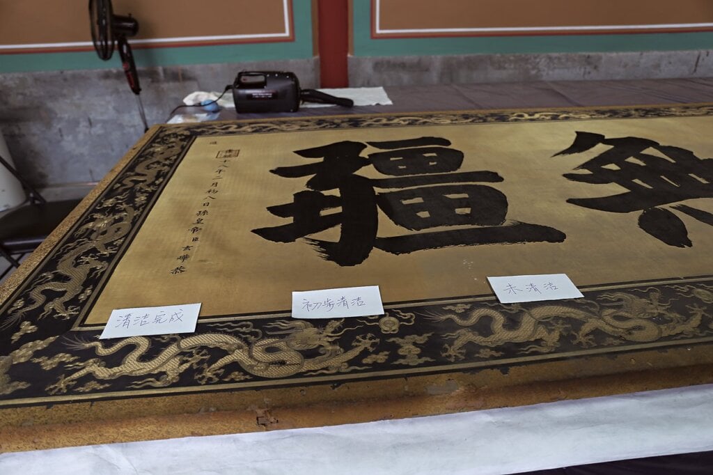 大匾表面的汙染物及清除前後對比。