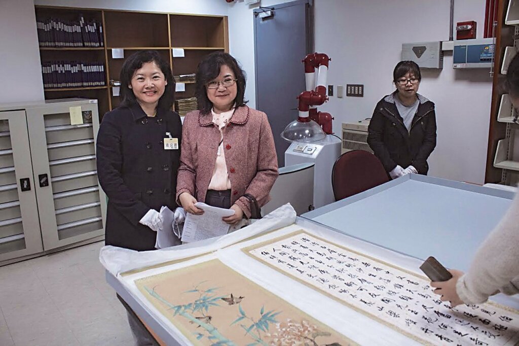 國立臺灣圖書館內執行〈2016陽明山中山樓珍貴動產2F季康書畫屏風修復案〉作業。凌春玉（左）與所長吳明珏（右）合影於國立臺灣圖書館。