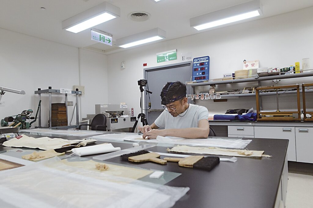 修復師林煥盛於國立臺灣圖書館修復的狀況。