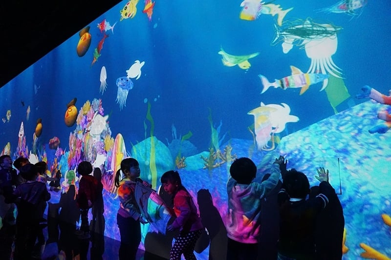 《彩繪水族館》的互動式作品，也是展場人氣最高的區域，看到自己手繪的 各類海洋生物成為作品的一部分，小朋友開心不已。（攝影／林亞偉）