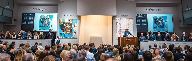 蘇富比夜拍現場,拍賣官旁即為Basquiat《無題》一作。(紐約蘇富比)