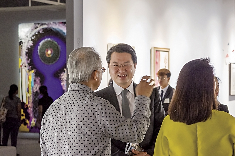 佳士得亞洲區副主席張丁元（中），與藏家於預展現場。圖｜佳士得香港