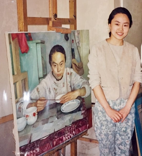 朝戈妻子與作品《桌前人物》合影。圖片提供：嘉德香港