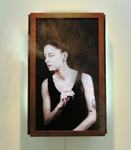 結合煙霧裝置的作品，讓觀者與抽菸的女人彷彿處在同一空間。《Art Student》．LCD panel、electronic device、steel、humidifier．58×38×14 cm．2014。Ed. AP/10 攝影：楊椀茹