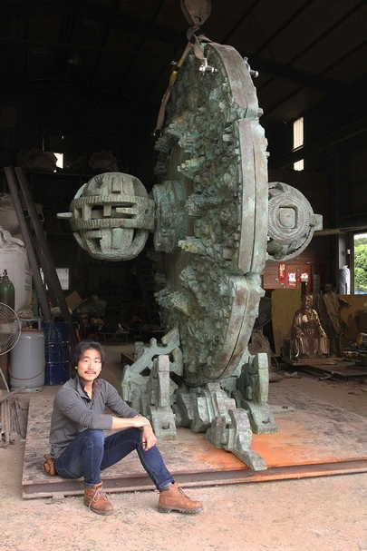 藝術家涂維政與英國卡斯雕塑基金會典藏的大型銅雕作品《魂遁之輪》。圖片提供：涂維政