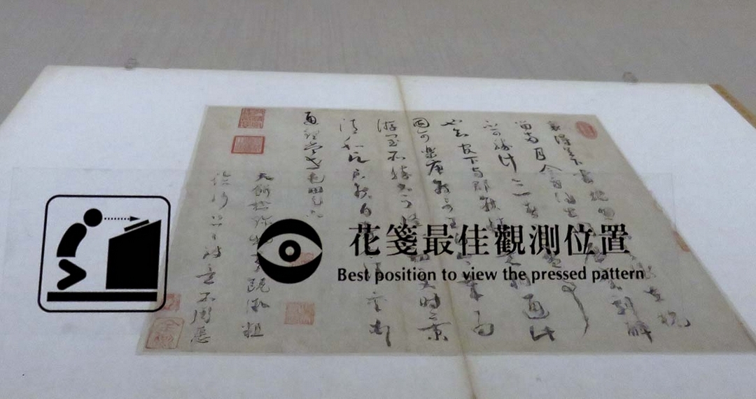 展場特別貼上「花箋最佳觀測位置」，讓民眾能夠找到隱晦的裝飾圖案。攝影／張筠。