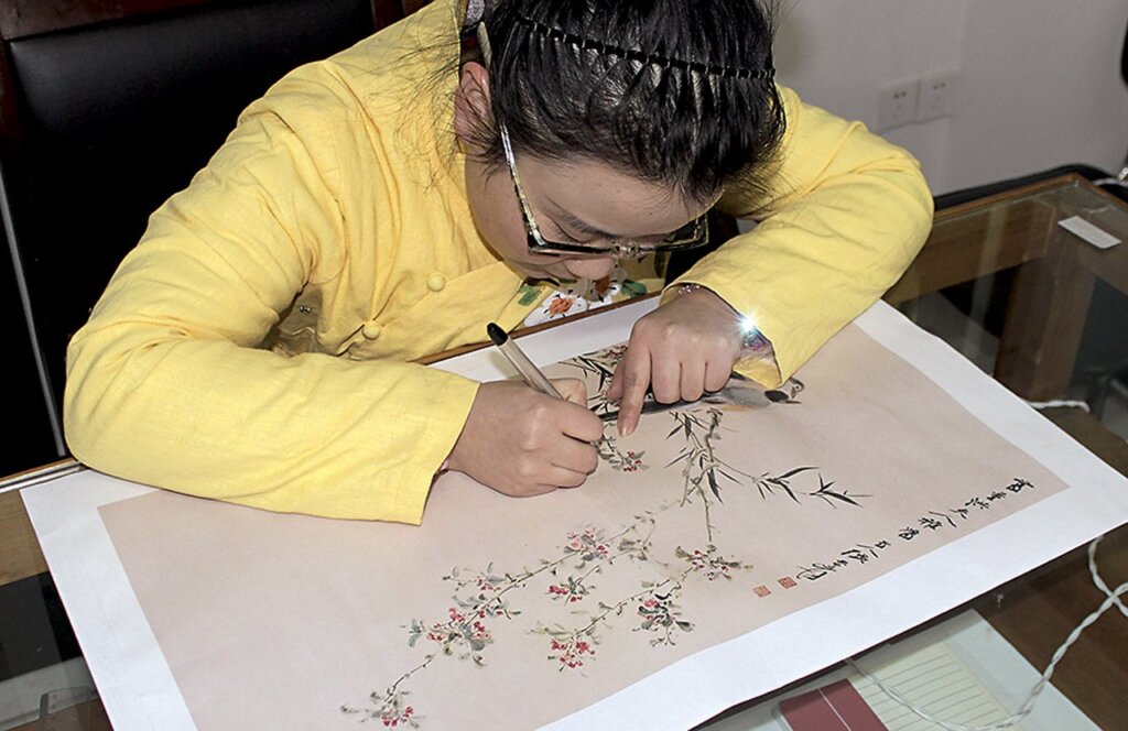 拓稿。將畫稿的塊面、輪廓以白描線條的形式落稿於刺繡底料上。