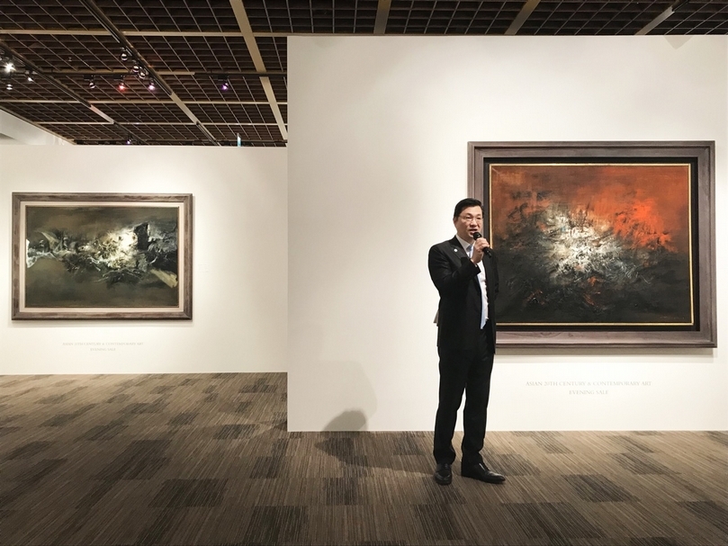 佳士得亞洲區副主席暨亞洲20世紀及當代藝術主管張丁元於台北預展現場介紹趙無極《14.12.59》，後方作品為趙無極《10.11.58-30.12.70》。（攝影／楊椀茹）