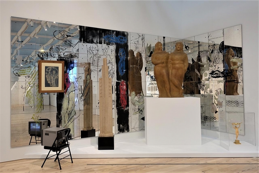 「傳送」(Transmissions)展覽現場,鏡面為尼克.莫斯(Nick Mauss)2018年新作《心的影像》(Images in Mind)。由左到右依序為,巴蘭欽(George Balachine)與舞者彩排錄影 1951-1958, 帕佛爾(Pavel Tchelitchew)的顱內風景 (Interior Landscape Skull, 1949),艾力內德曼的兩個馬戲女(Two Circus Women),古斯塔夫的雕像。(黃彥榕提供)