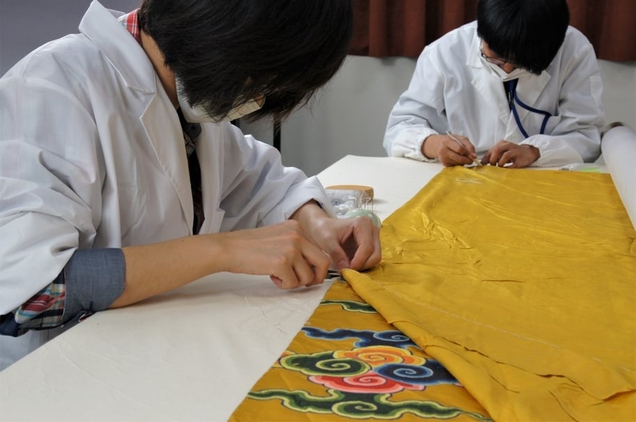 織品修護工作。（國立故宮博物院提供）