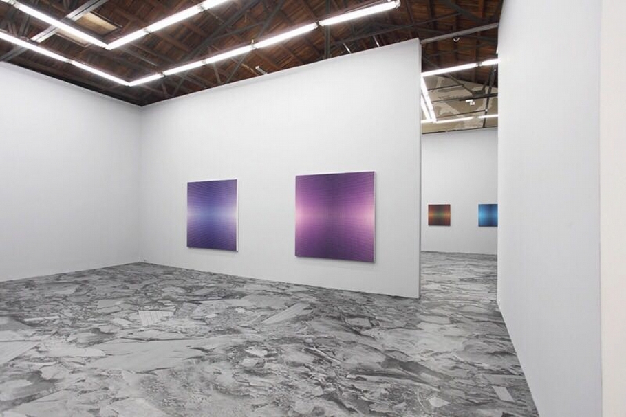 2014年北京公社的「謝墨凜:燦.爛」現場,這個展覽中謝墨凜將他工作室所在黑橋村雜亂殘破的地面列印成圖片貼在展廳的地面上,雜亂的現實場景和他的抽象作品之間形成了有趣的對比。(北京公社提供)
