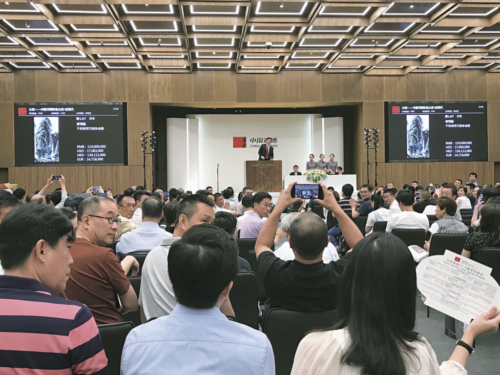 中國嘉德：〈千巖競秀萬壑爭流圖〉由現場一位女士舉牌得標。攝影／藍玉琦。
