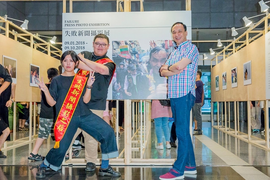 「第一屆失敗新聞攝影大賞」展覽開幕時眾星雲集，多位政治人物到場為自己的失敗照留下簽名，現任新北市市長朱立倫與得獎者合影。（失敗新聞攝影大賞提供）