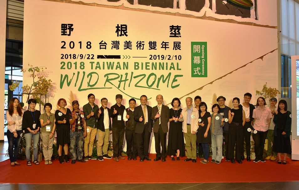 「野根莖–2018台灣美術雙年展」於國立台灣美術館的開幕現場，文化部蕭宗煌次長（左10）、台中市文化局施純福副局長（左9）、國美館陳昭榮代理館長（左11）、策展人龔卓軍（左8）、周郁齡（左12）及參展藝術家合影。（國立台灣美術館提供）