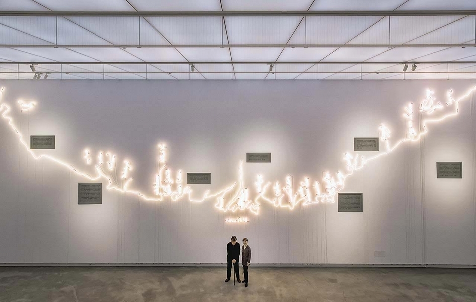 高美館館長李玉玲（右）與藝術家科蘇思（Joseph Kosuth）攝於作品《世界地圖》（Mappa Mundi）之前。（高雄市立美術館提供）