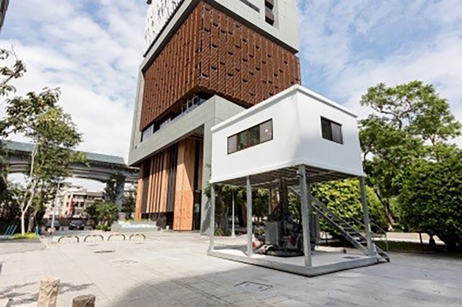日本藝術家西野達作品《大砲花瓶》，上二樓是台灣客廳的擺設，中間桌上插著鮮花的花瓶，事實上是一樓雙管砲砲管之延伸。圖｜忠泰美術館