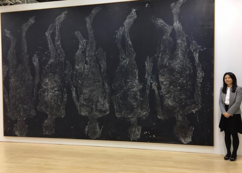 高古軒畫廊（Gagosian）資深總監王涵怡與巴塞利茲作品《5 mal endwärts》合影。（本刊資料室）