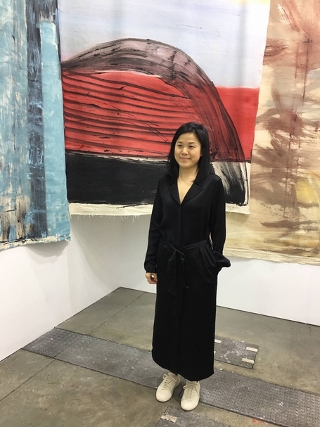 格萊斯頓畫廊（Gladstone Gallery）總監蔡秉橋，與蘇特的3件繪畫作品合影。（本刊資料室）