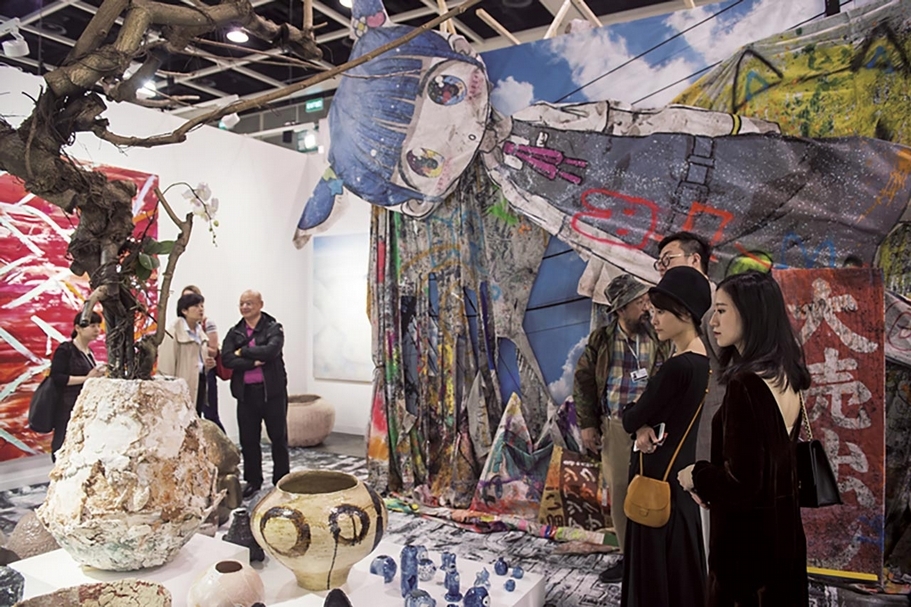 2018年，Kaikai Kiki Gallery展位，吸睛力十足，右四為畫廊創辦人、藝術家村上隆。（香港巴塞爾藝術展提供）