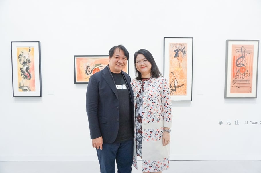 尊彩藝術中心負責人余彦良、陳菁螢夫婦於李元佳作品前合影。（本刊資料室）