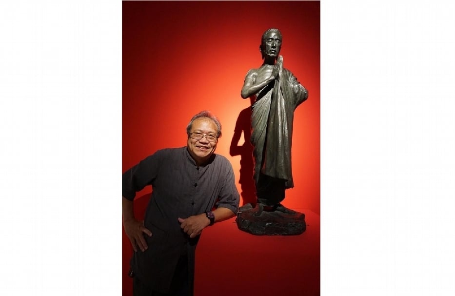 策展人蕭瓊瑞，與黃土水《釋迦出山》翻銅作品合影。（攝影／林亞偉）