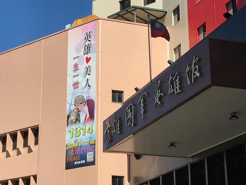 高雄國軍英雄館外觀,有于右任題字的「高雄國軍英雄館」,以及「英雄愛美人」愛河產業鏈的帆布條。(攝影/陳漢聲)
