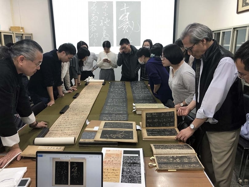 「水月鏡像」展覽籌備前期，盧慧紋與藏家康益源（左一）、前國立故宮博物院副院長何傳馨（右一）及研究生們共同討論鑑賞多本懷素〈自敘帖〉。