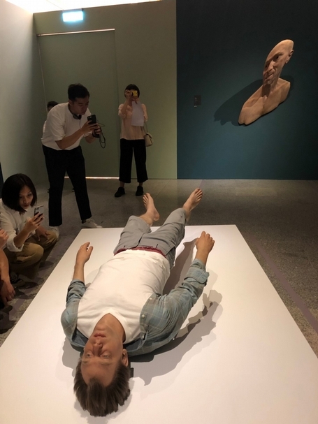 在這個空間中，彷彿沒有重力、沒有一定的存在形式。前方的男子以一種奇怪的姿勢懸浮在空中，沒有重心地躺著。後方的半身像則以變形的角度來呈現作品，不管觀者站在哪裡看，人物都是扭曲歪斜的樣子。