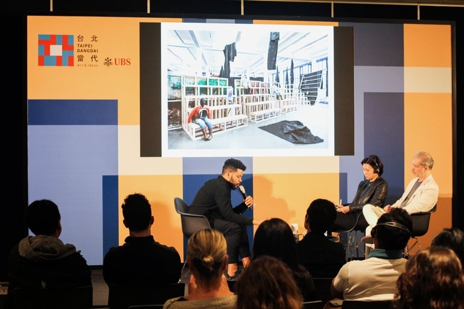 新觀點共享平台：奧斯卡 · 穆里略（Oscar Murillo，左）座談現場，共同參與者包括英國籍視覺人類學家馬塞爾（Marcel Reyes-Cortez，右）以及空總臺灣當代文化實驗場執行長賴香伶（中）。（台北當代藝術博覽會提供）