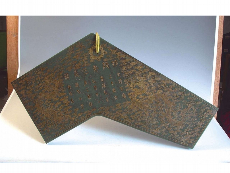 清《乾隆款碧玉淺雕描金雲龍特磬》 前股長62公分，寬20.6公分，後股長41.5公分，寬30.7公分，厚3.5公分。特磬玉質光澤溫潤，為新疆和闐碧玉製成。磬體兩面滿刻陰線描金雲龍紋飾，花紋精密流暢，圖案外部有描金雙框線。正面刻有特磬律名及製成年款：「特磬第三太簇。大清乾隆二十有六年，歲在辛巳冬十一月己未朔，越九日癸卯琢成。」背面刻有120餘字的乾隆皇帝御製銘文，闡述以新疆和闐玉製造特磬的淵源及意義。兩面銘文內均填金，在雕刻的火焰珠內琢以圓孔，孔內穿繫黃絲繩，用於懸掛演奏。 特磬是清朝宮廷禮樂遺物
