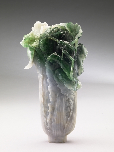翠玉白菜 (清)。白菜，古人稱之為「菘」，寓意士人要淡薄自甘，不惑於富貴。翠玉白菜上兩隻草蟲，分別為大螽斯與小蝗蟲，都是多產的象徵。（圖片來源：故宮南院官網）