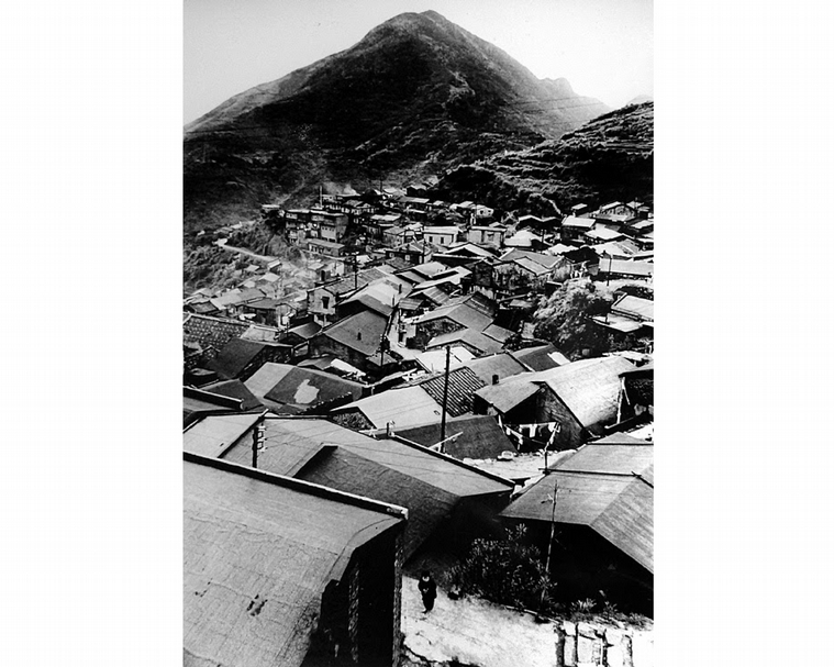 鄭桑溪以「雞籠山」地標為背景鳥瞰九份山城，九份，1960。（鄭天全提供）