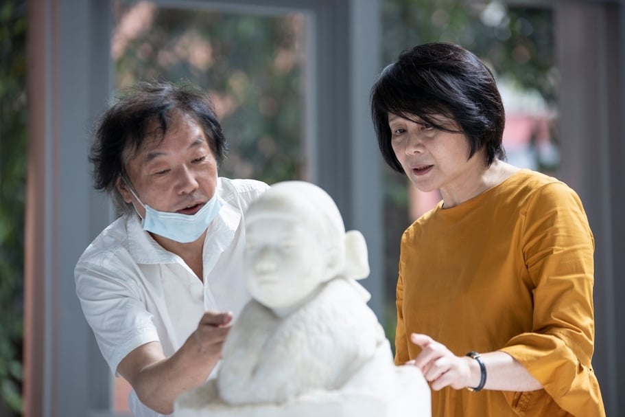 展覽總策畫林曼麗與修復師森純一討論修復事宜。（北師美術館提供）