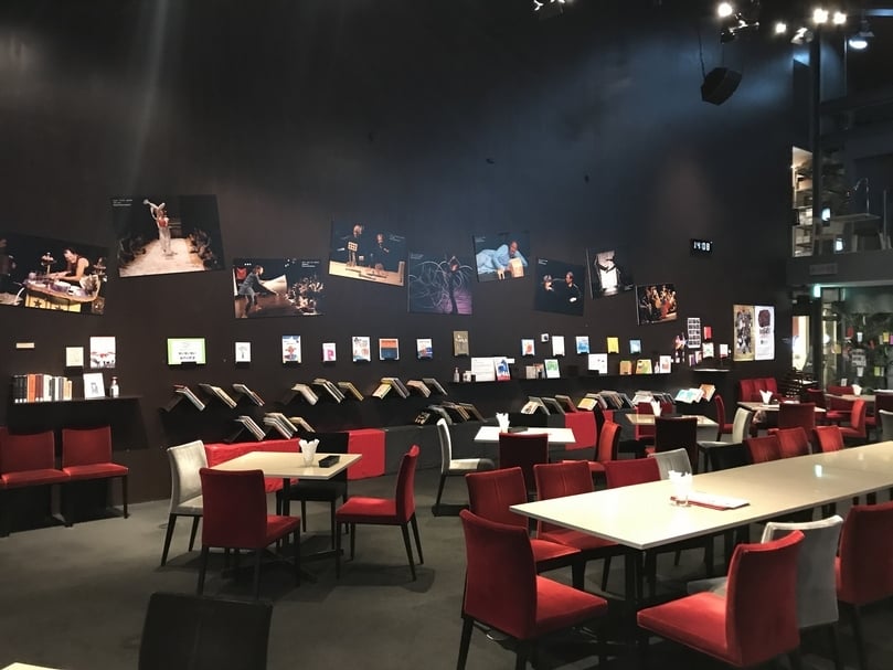 這間咖啡廳內有250本以上的繪本，放在一整面漆成黑色的牆面上，顧客可以 一邊享用餐點，一邊欣賞繪本。