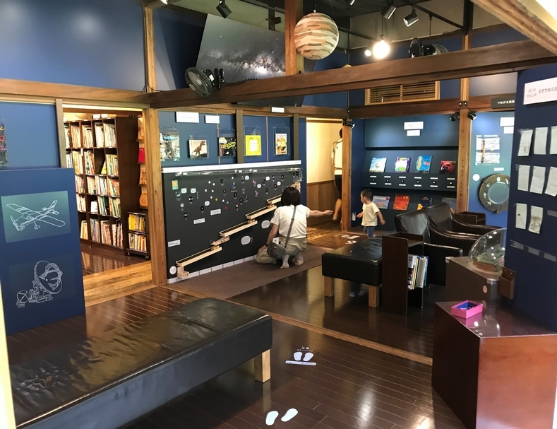 天花板上懸掛著太陽系的行星，地板上標示出行星與太陽間的距離，距離都是等比例縮小。
