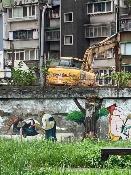 臺拓糧倉拆除現場，前方圍牆為社區營造所描繪米勒的「拾穗」，看來格外諷刺。（攝影／蕭文杰）