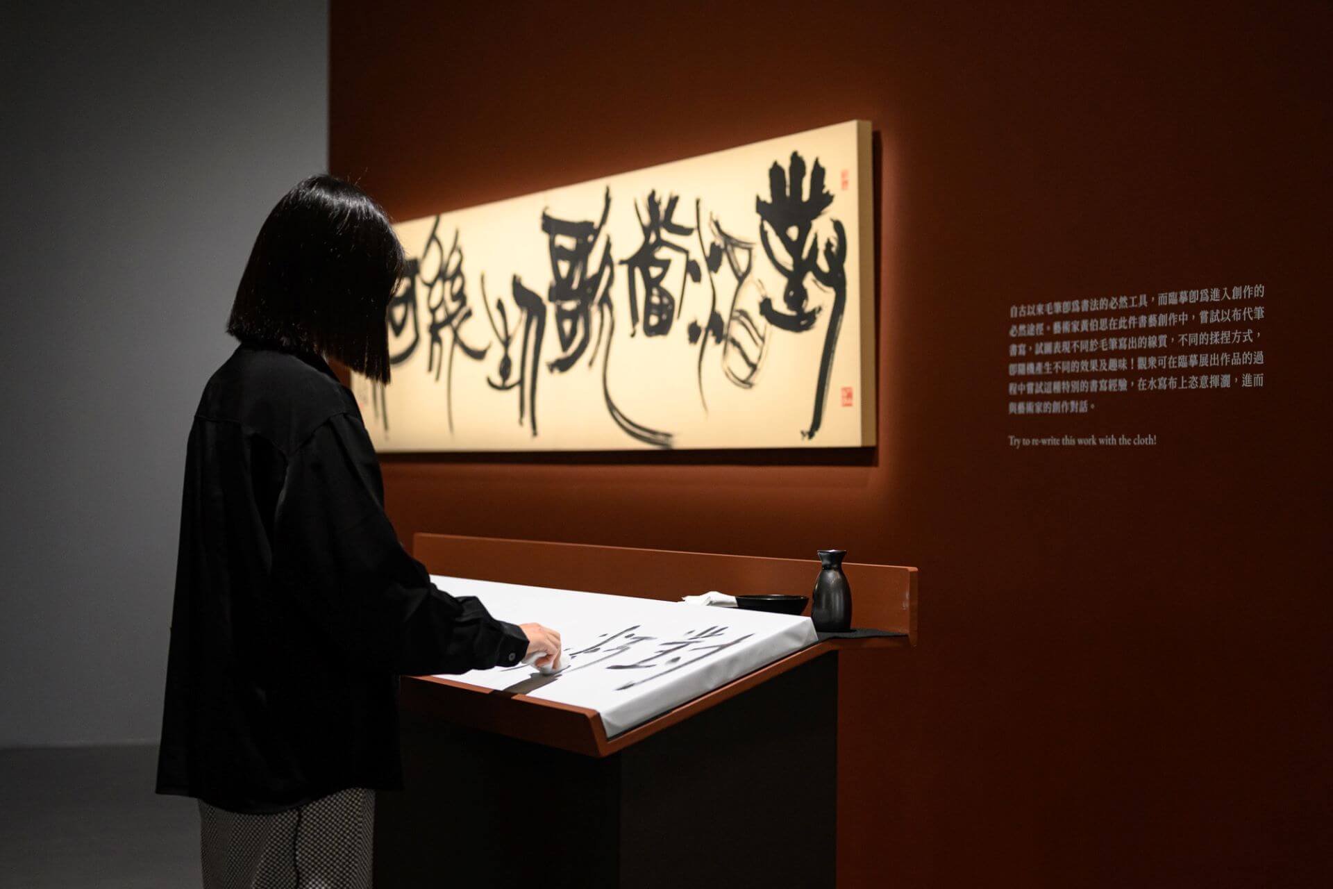觀眾體驗以布代筆書寫，臨摹藝術家黃伯思作品〈曹孟德短歌行詩句〉。（攝影／ANPIS FOTO王世邦 圖片提供／桃園市立美術館）