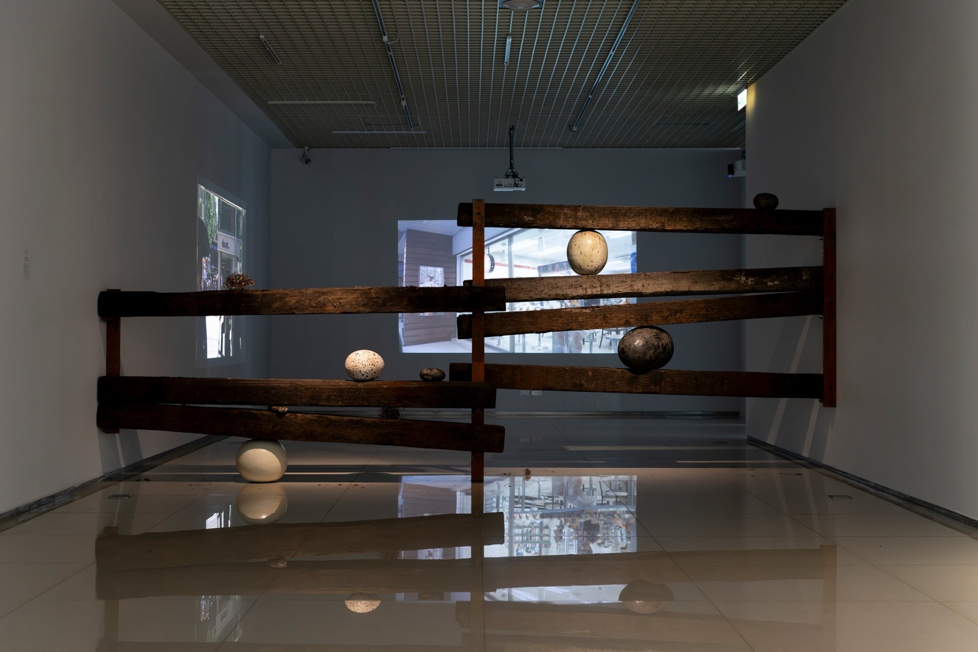 二樓「疆界注」子題展出魏柏任的《凝固的空格》，枕木、黑鐵、紅銅絲、骨灰粉、檜木屑、鉛筆屑、日本瓷土、半瓷土、台灣黃陶土、美國黑土、釉料，2024。（嘉義市立美術館提供，攝影｜吳欣穎）