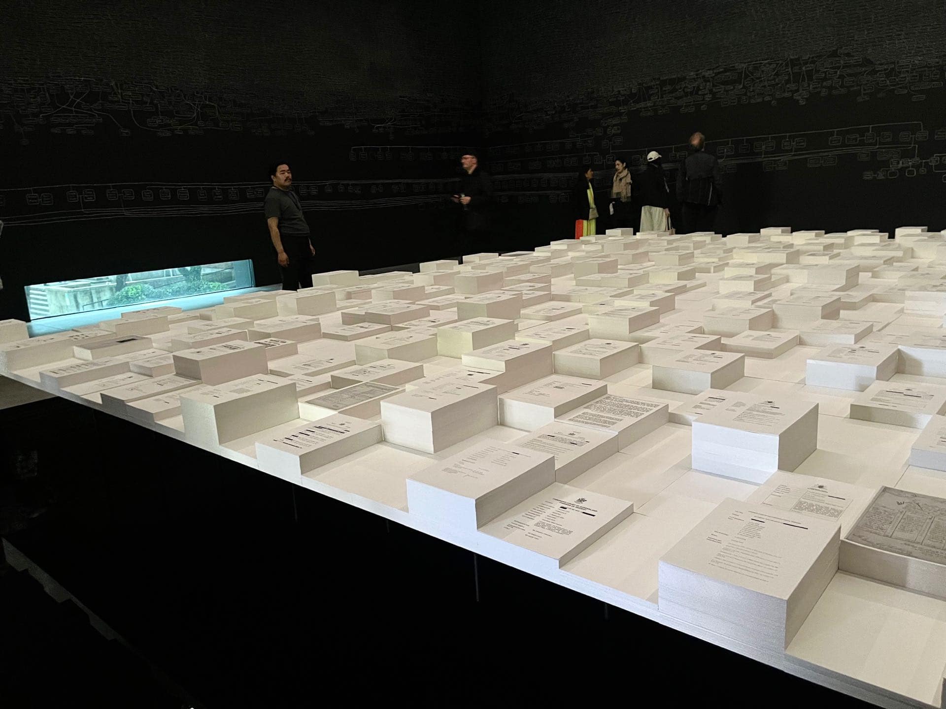 展場中央也建造了一座大型水池，水池中有一方型平台，平台上放置了高低不等的檔案文件，文件顯示澳洲原住民在警察拘留期間的死亡事件。圖為澳洲館展覽現場。攝影／陳思宇